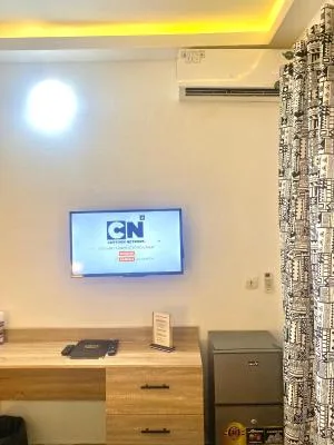 Espacio representativo del hotel: Una habitación con un televisor sobre una cómoda de madera.