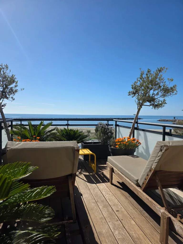 Representative hotel space: An outdoor terrace with seating overlooks the sea.