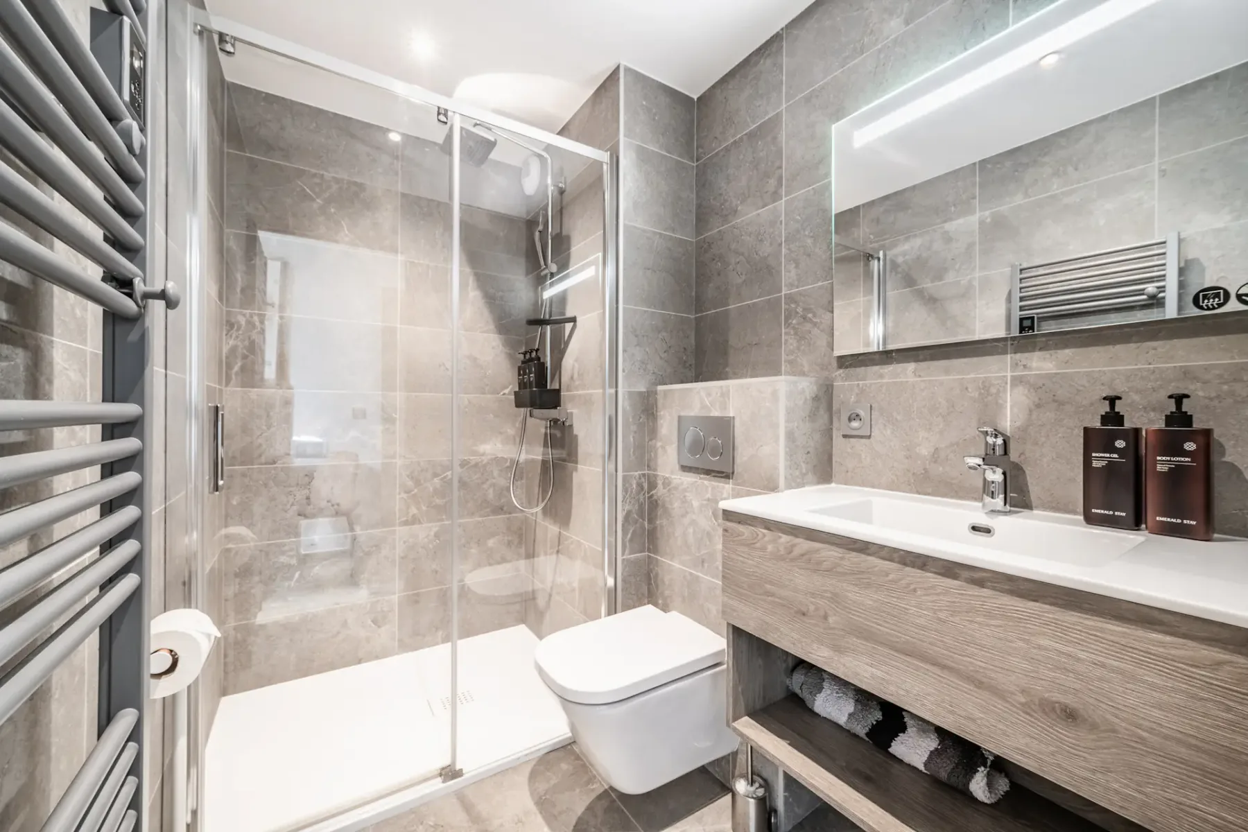 Un baño moderno con una ducha de vidrio y un lavabo con mueble.