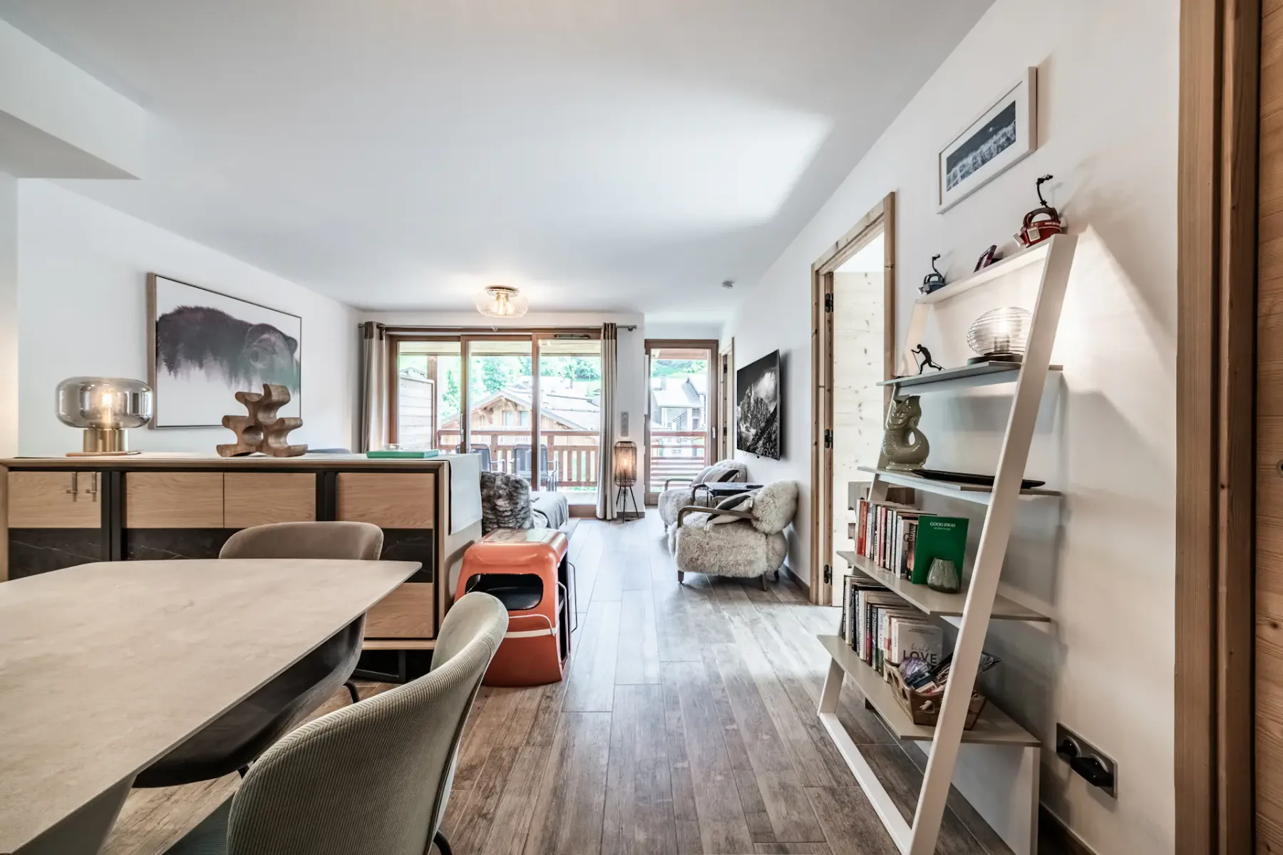 Una sala luminosa con mesa de comedor, asientos y ventanas amplias.