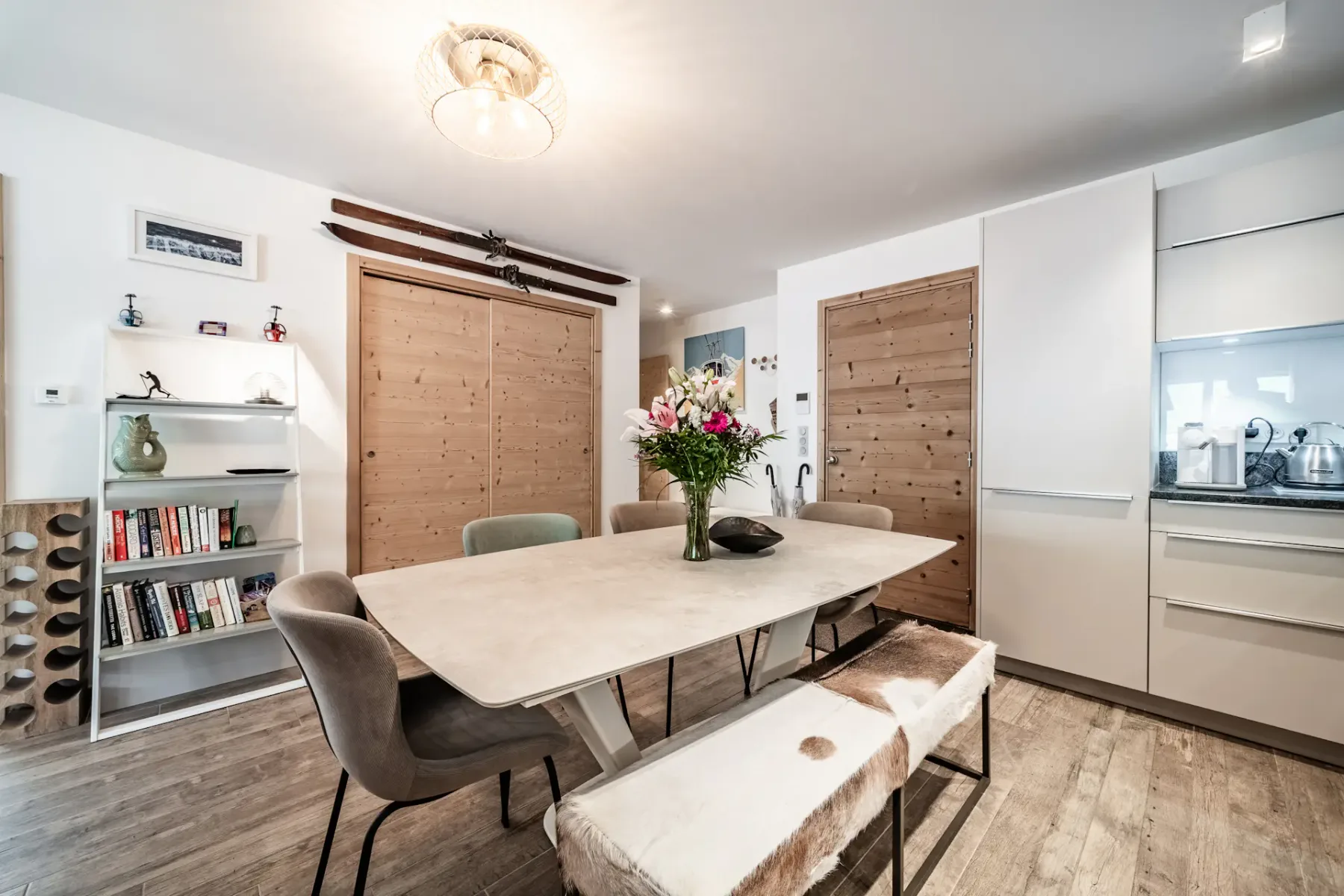 Comedor con una mesa, asientos y puertas de madera.