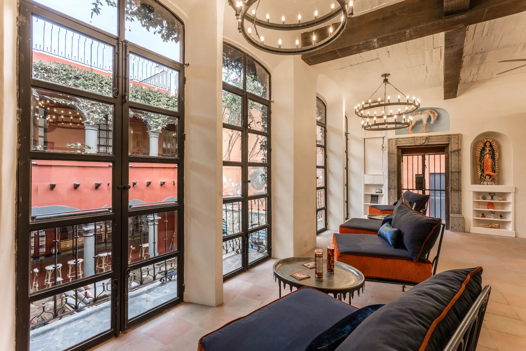 A bright lounge with tall arched windows and cushioned seating.
