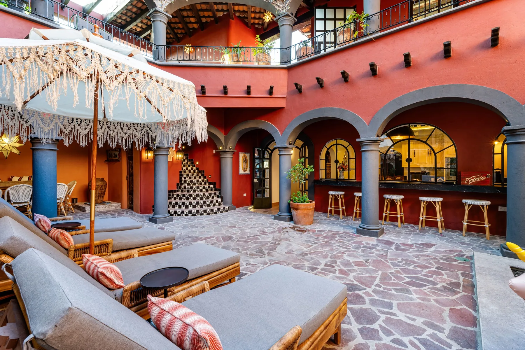 A courtyard lounge with cushioned seating and an arched bar.