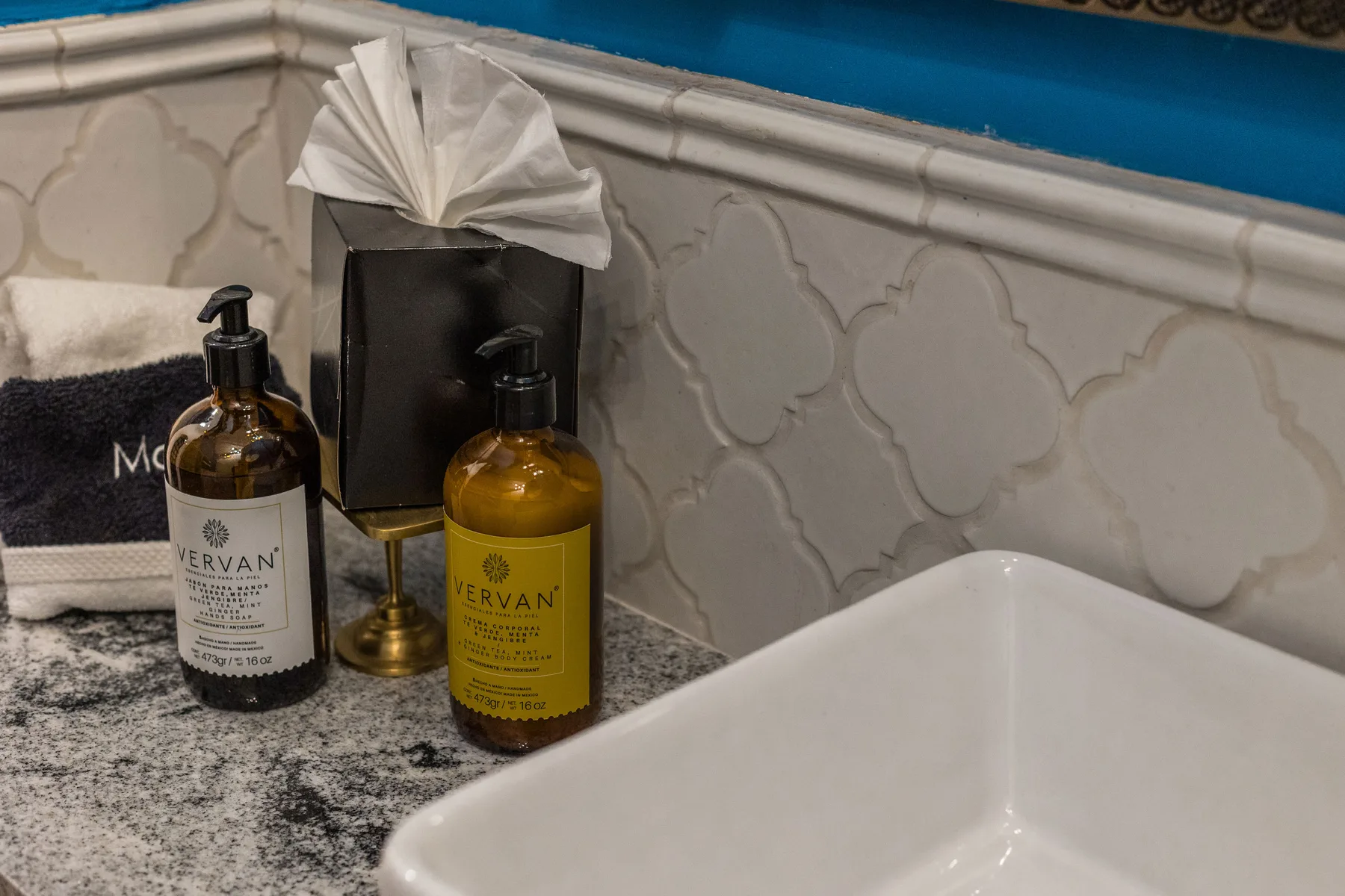 A bathroom vanity with a white sink, soap bottles, and folded towels.