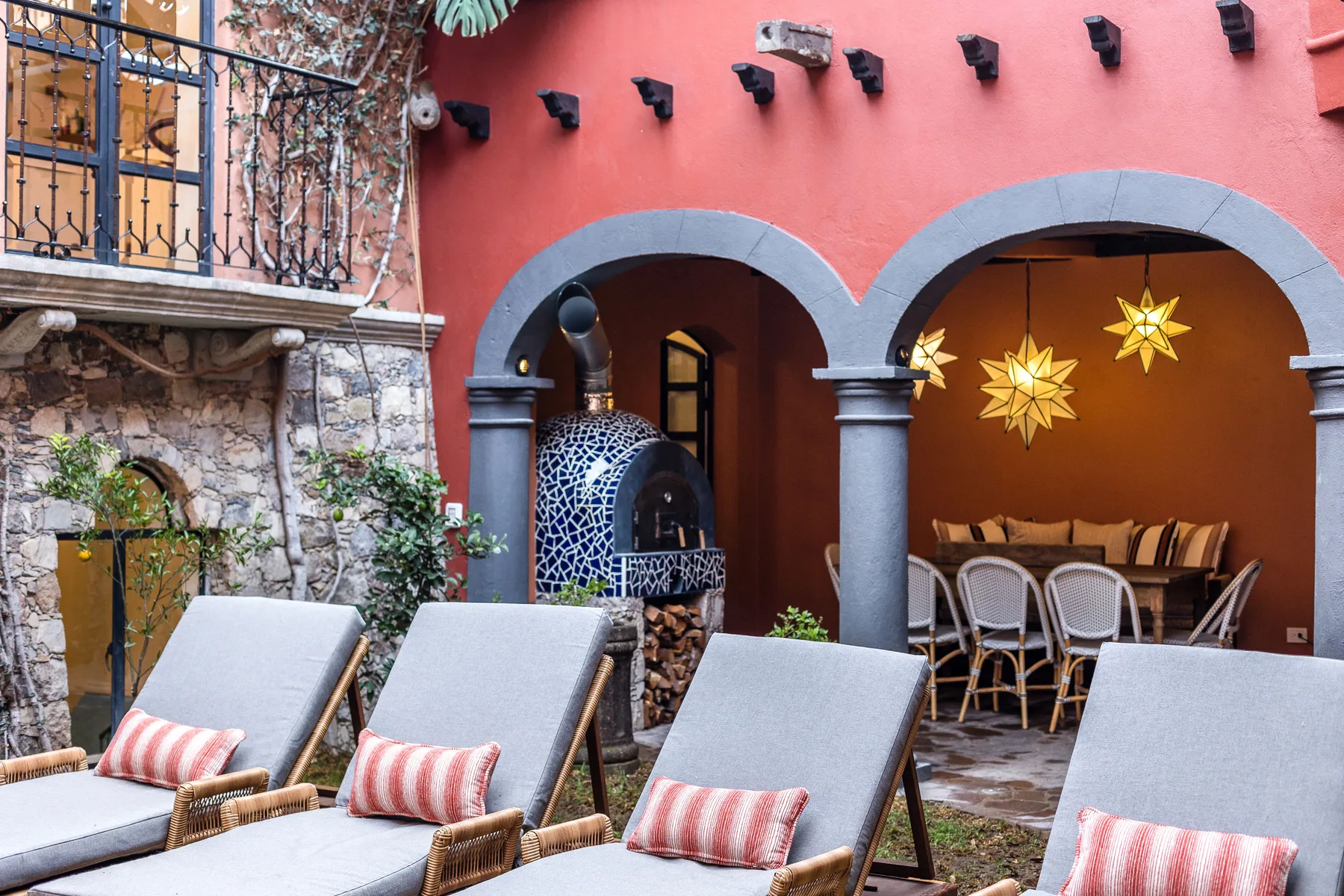 A courtyard patio with lounge seating and an arched dining area.