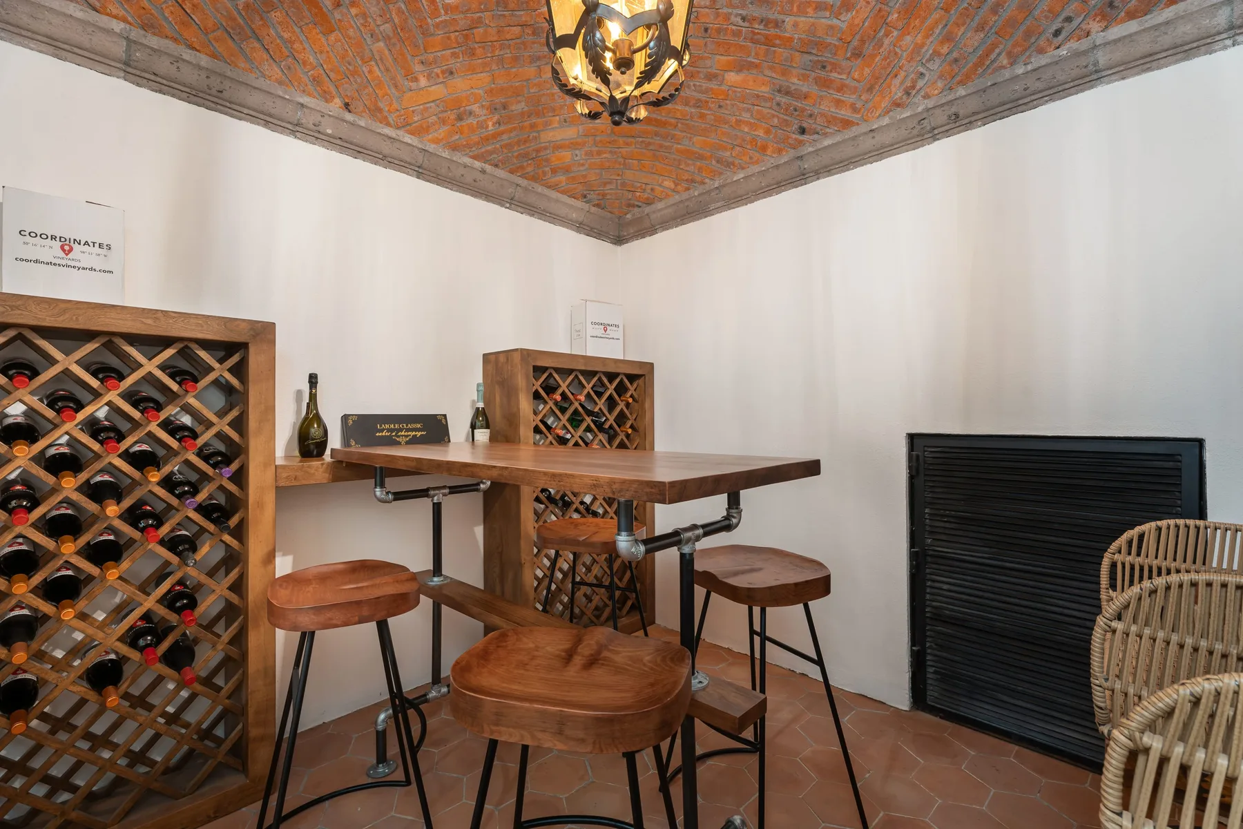 A wine cellar with wooden wine racks and a counter with seating.