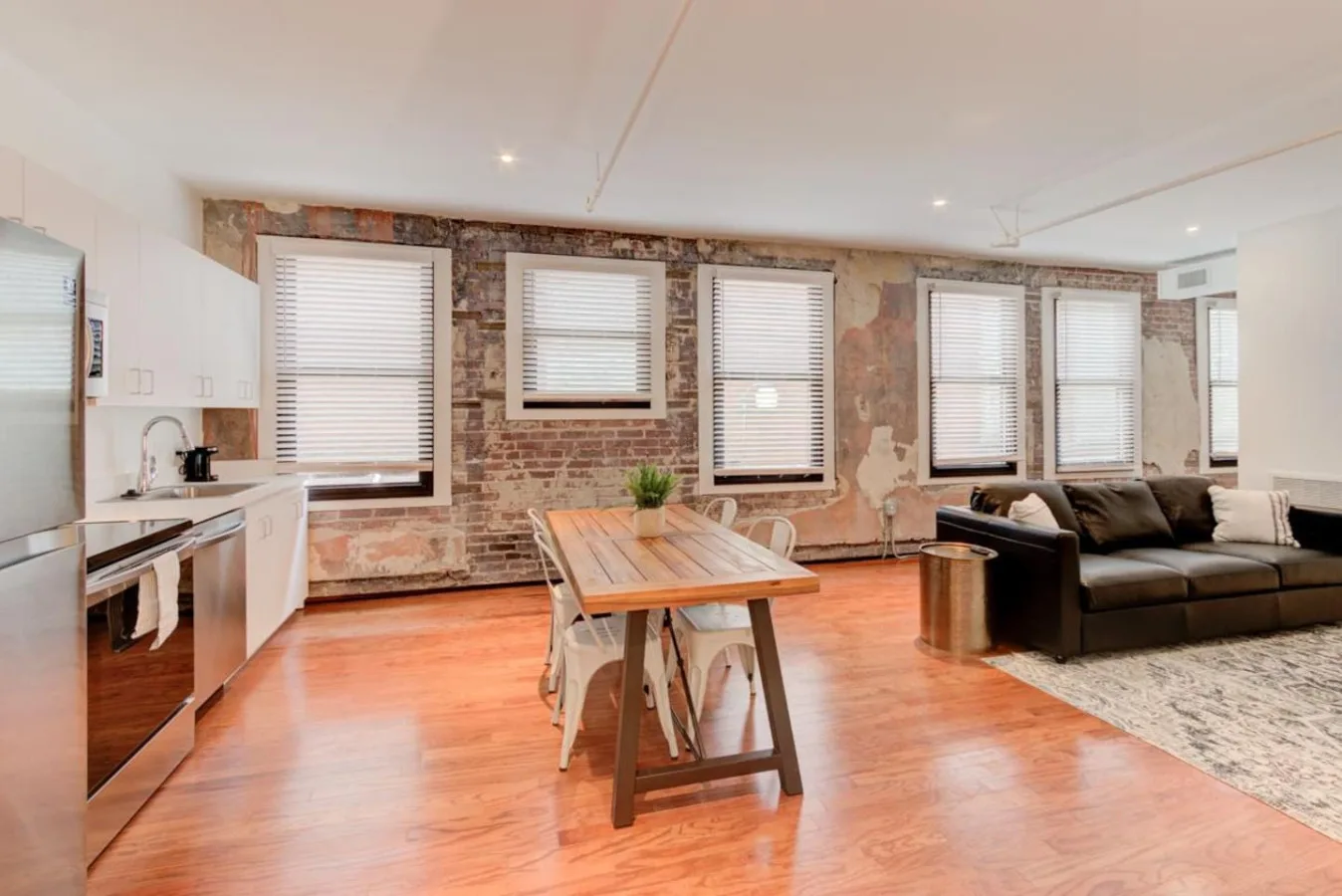 A bright open-plan living area with a dining table, kitchen, and seating.