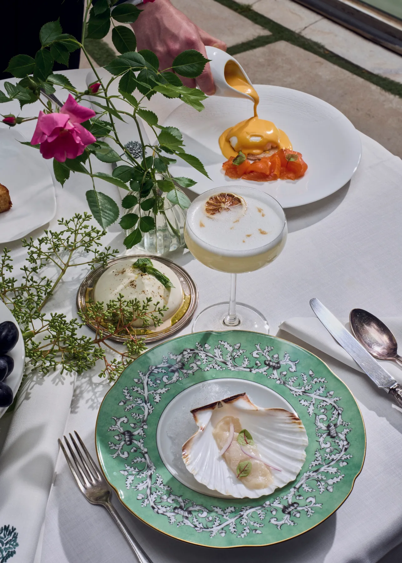 Representative hotel space: A plated meal with decorative dishes and a sauce being poured at the table.