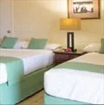 Representative hotel space: A bedroom with two beds, bedside tables, and framed wall art.