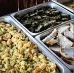 Representative hotel space: A buffet spread includes cooked food in several metal serving trays.