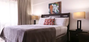 Representative hotel space: A bedroom with a bed, bedside tables, and artwork above the headboard.