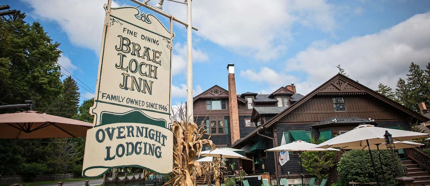 Representative hotel space: A roadside sign stands in front of a rustic inn building.