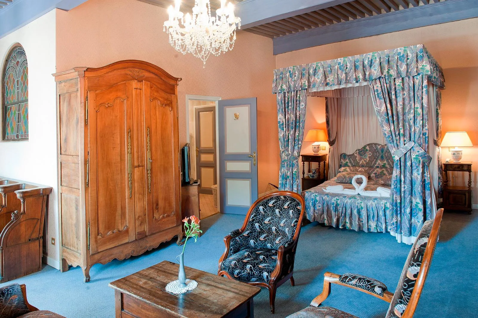 Representative hotel space: A furnished bedroom with a canopied bed, wardrobe, and seating.