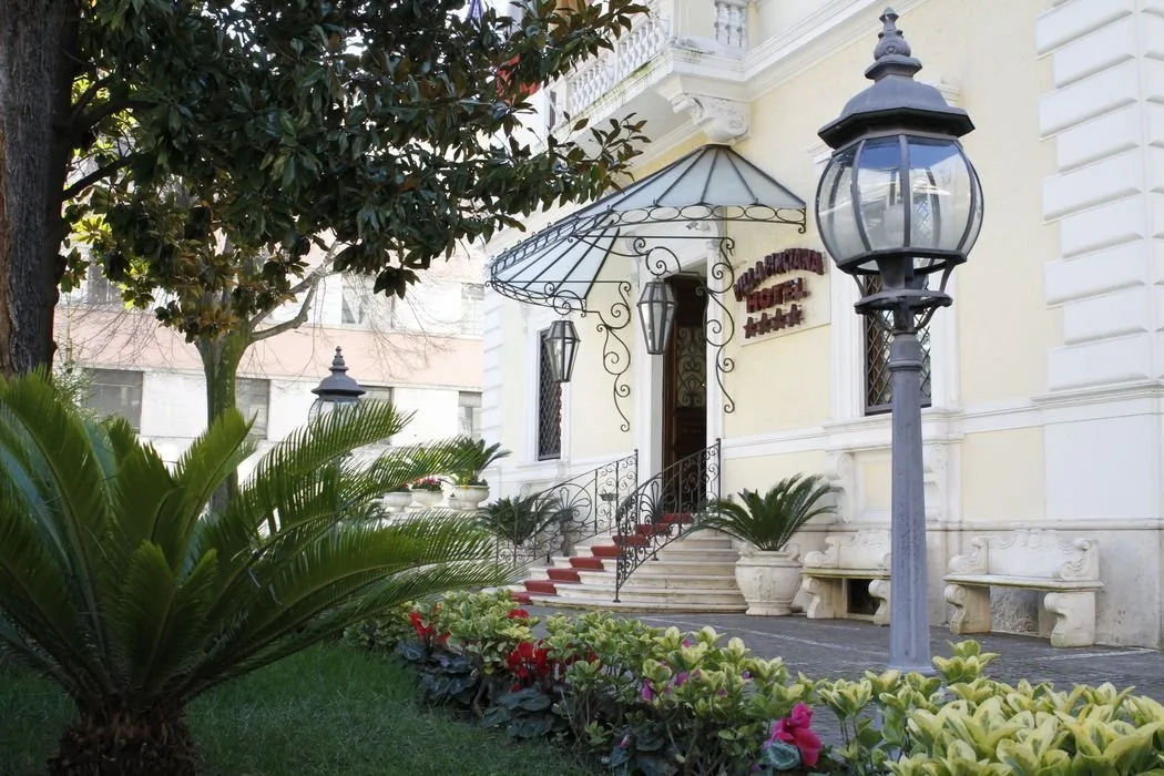Representative hotel space: A hotel entrance with steps, decorative ironwork, and landscaped plants.
