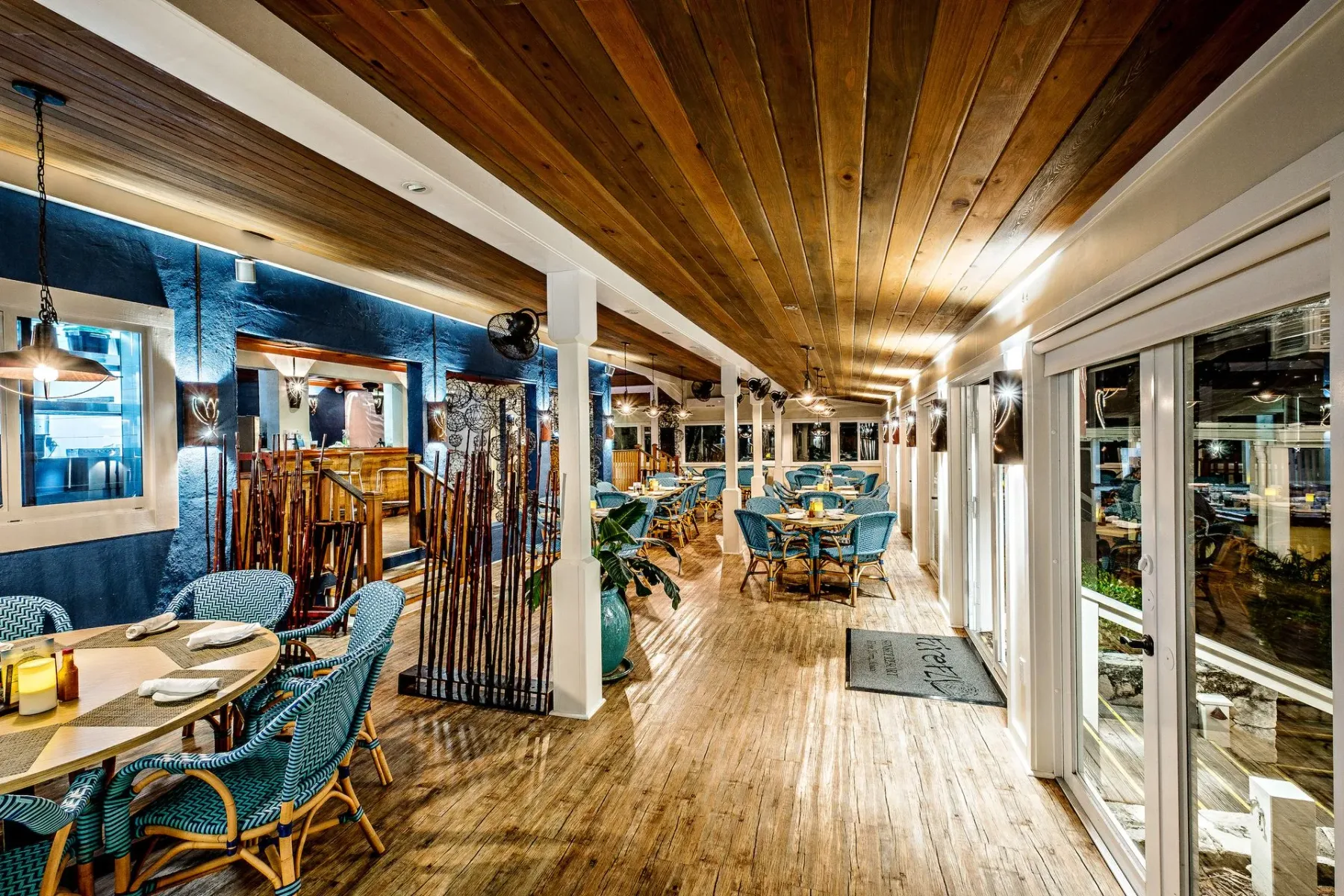 Representative hotel space: A dining area with tables and seating beneath a wooden ceiling.