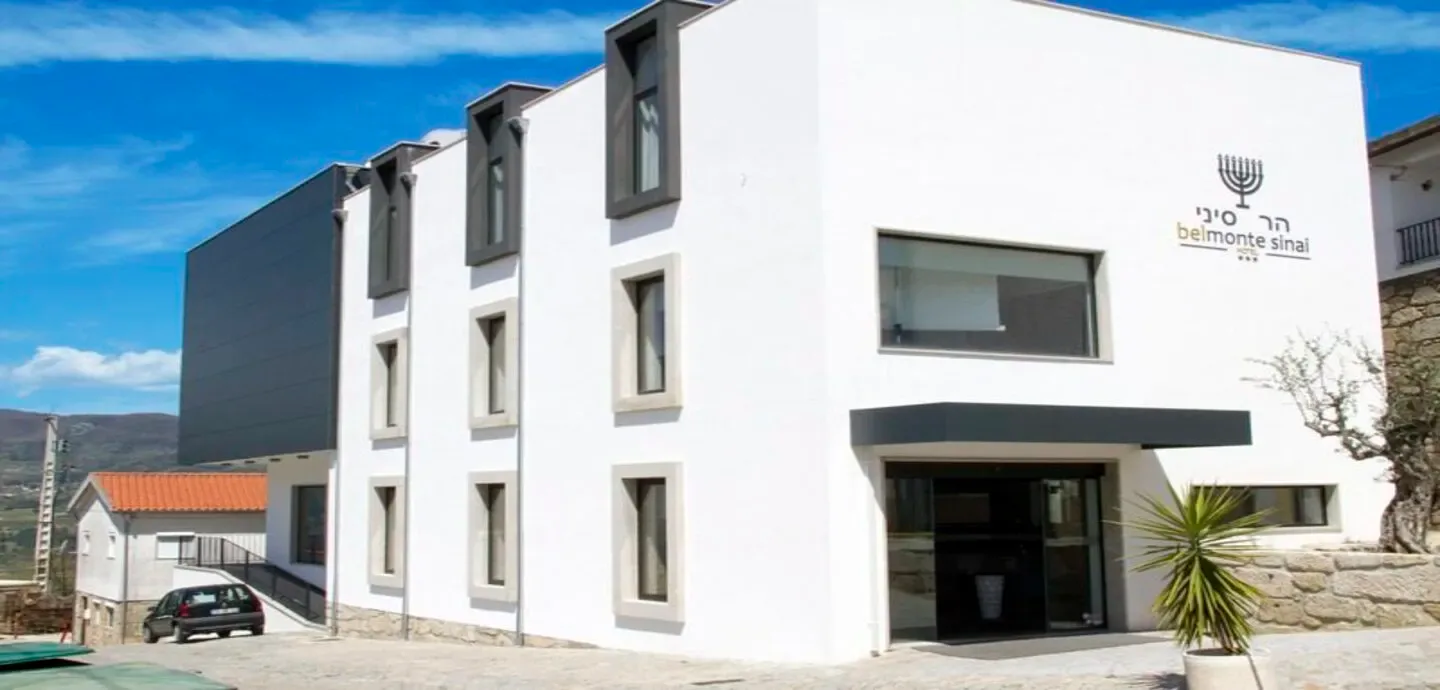 Representative hotel space: A modern white building with a dark entrance and rectangular windows.