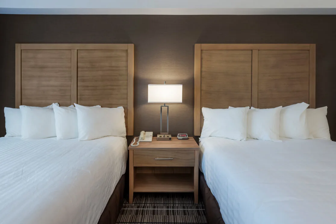 Espacio representativo del hotel: Un dormitorio de hotel con dos camas y una mesa de noche entre ellas.