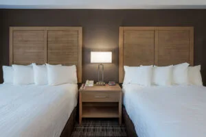 Espacio representativo del hotel: Un dormitorio de hotel con dos camas y una mesita entre ellas.