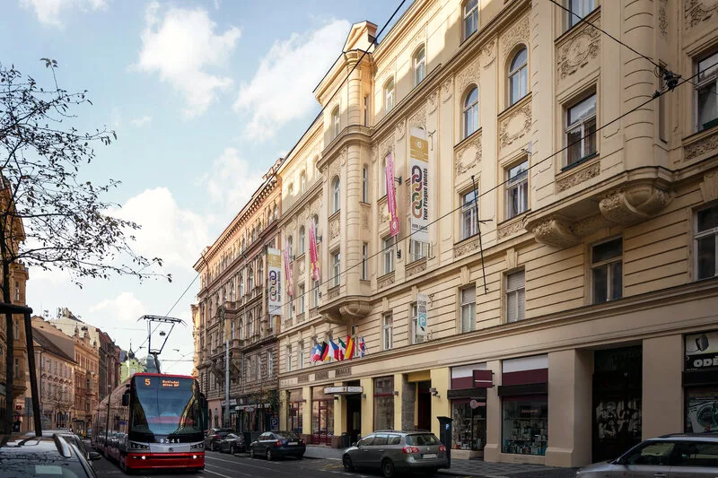 Espacio representativo del hotel: Una calle urbana con un edificio ornamentado y un tranvía.