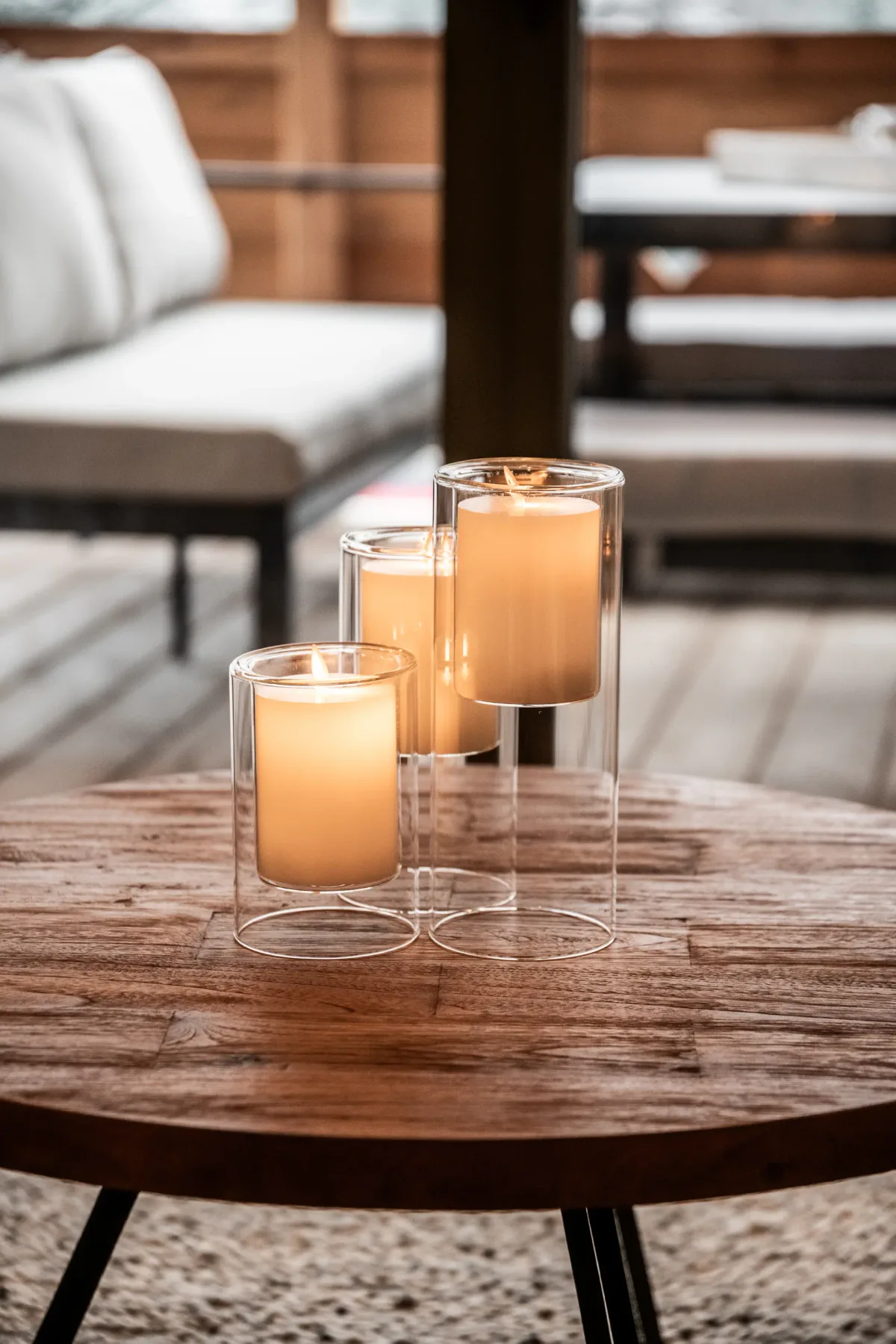 A living room seating area with lit candles on a wooden coffee table.
