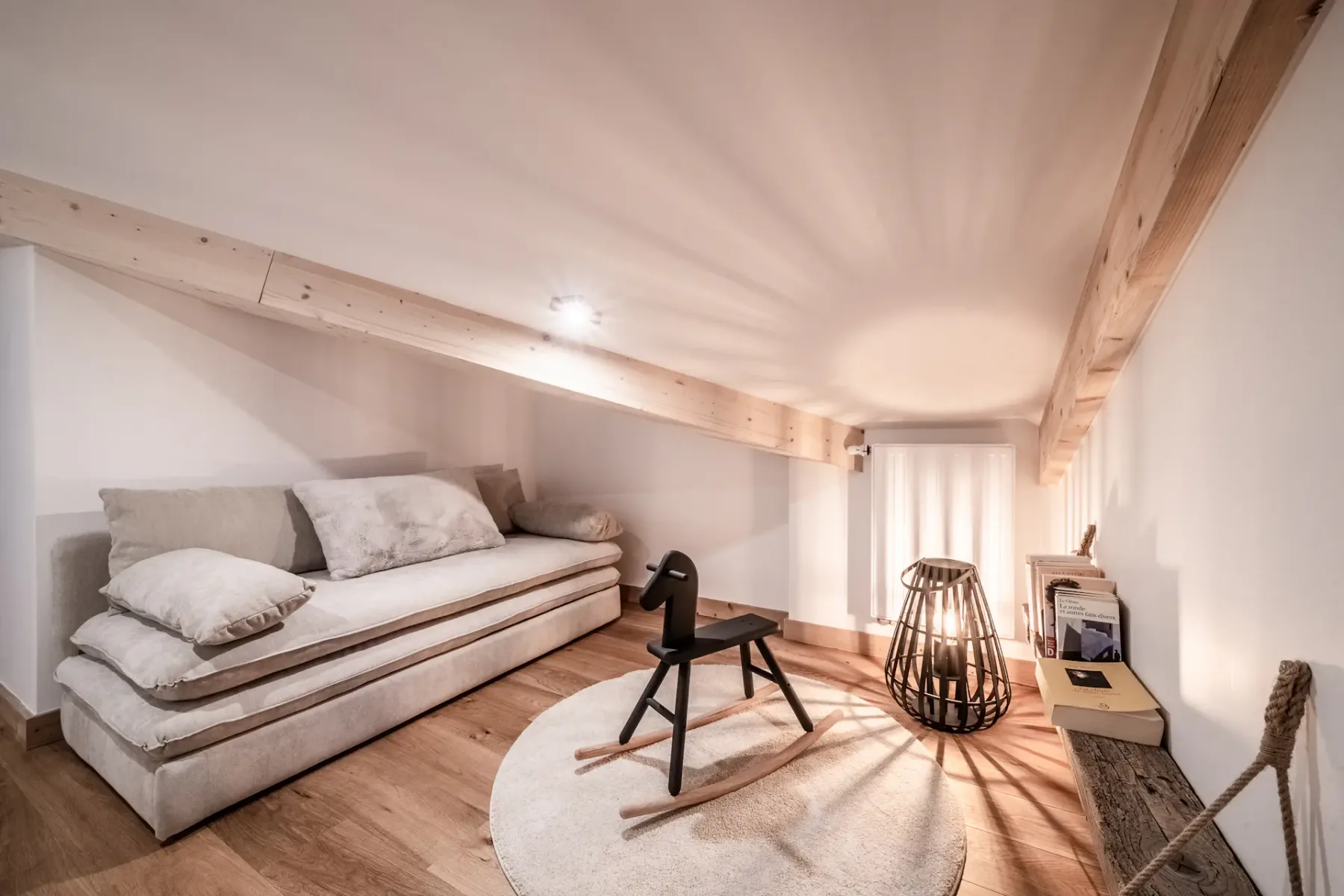 A cozy attic sitting area with a low couch and a rocking chair.