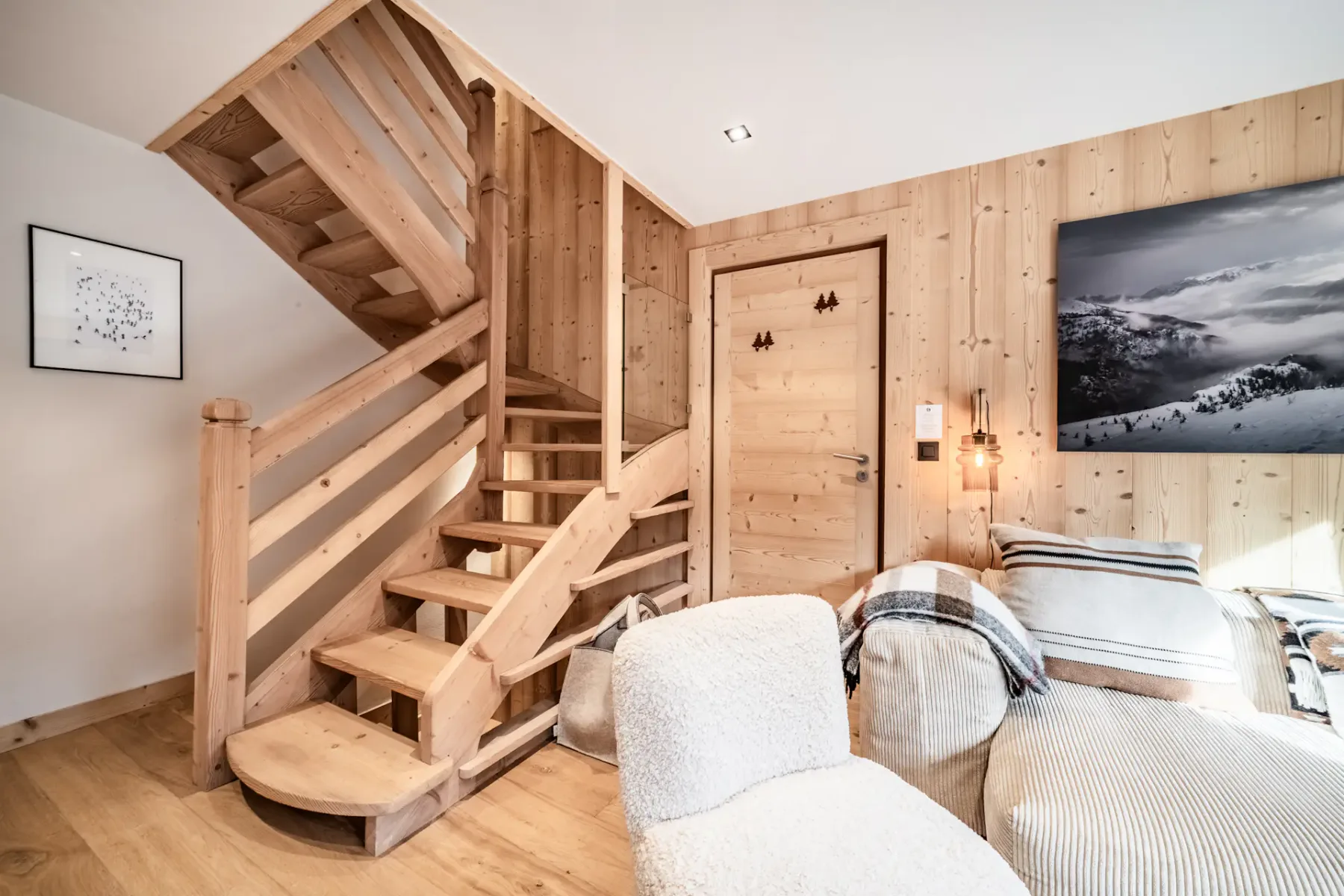 A wood-paneled bedroom with a staircase and beds.