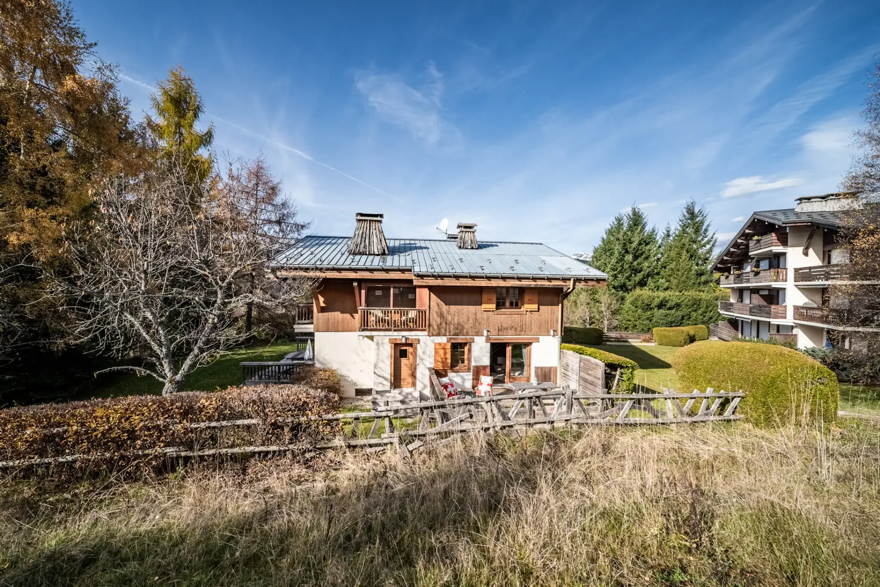 Shared amenity: A chalet-style building stands beside a grassy yard and trees.