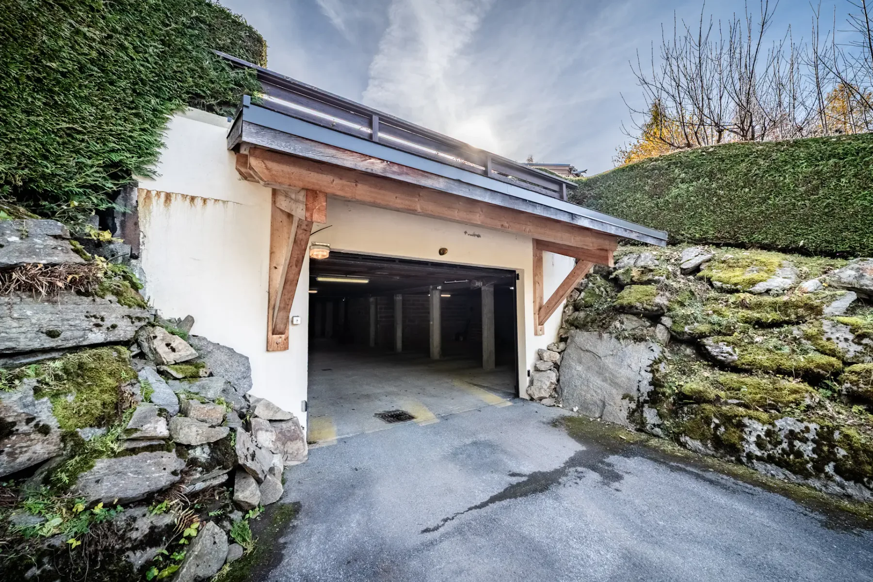 Shared amenity: An open garage entrance set between stone retaining walls and greenery.