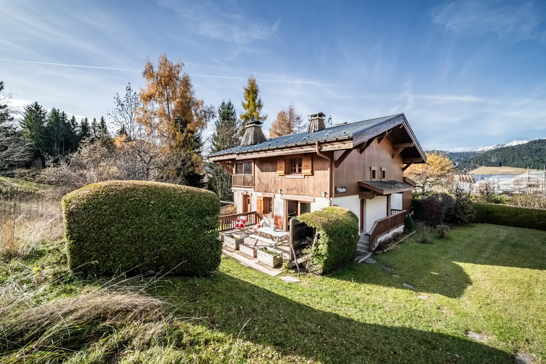 Shared amenity: A wooden chalet stands in a grassy yard surrounded by clipped hedges.