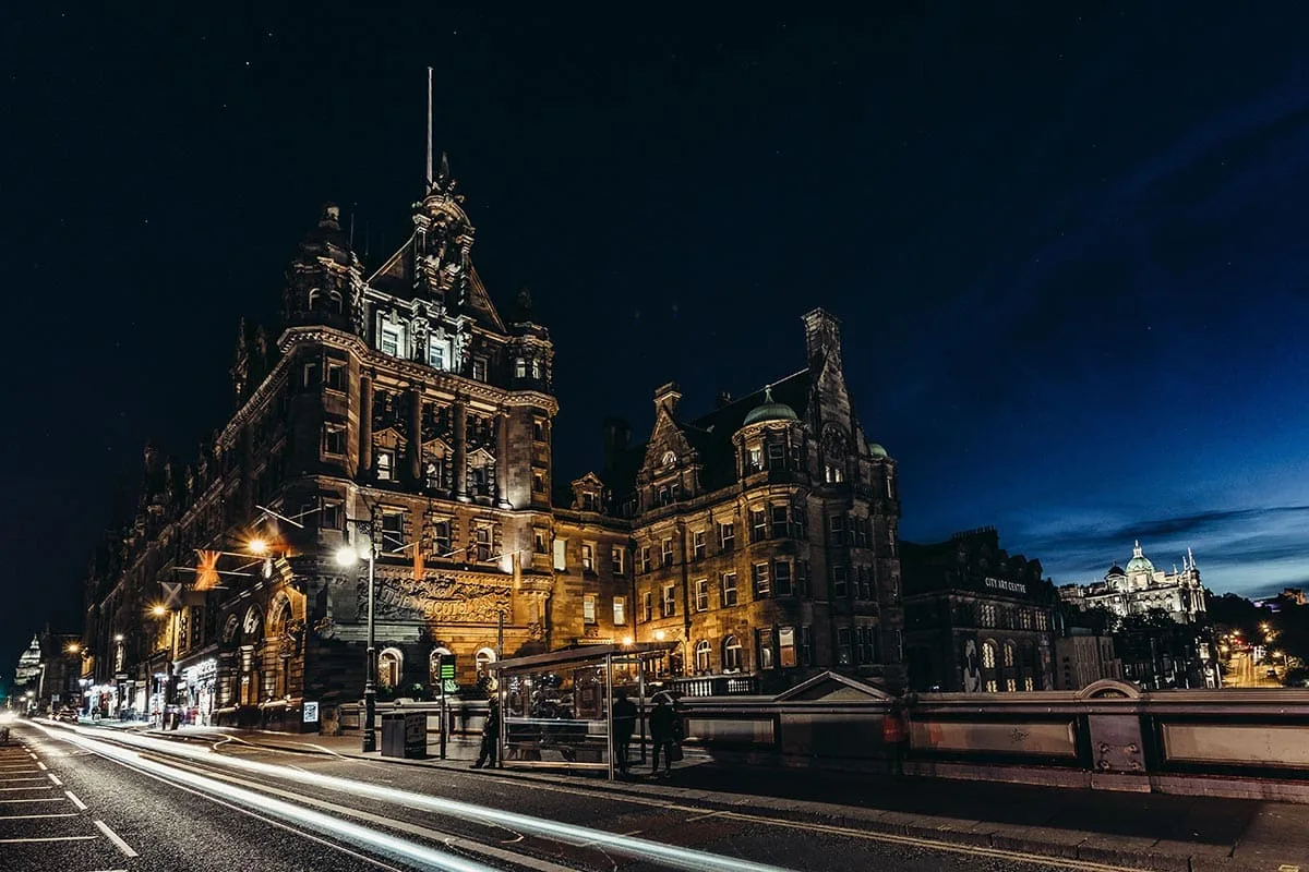 Representative hotel space: A grand illuminated historic building stands beside a city street at night.