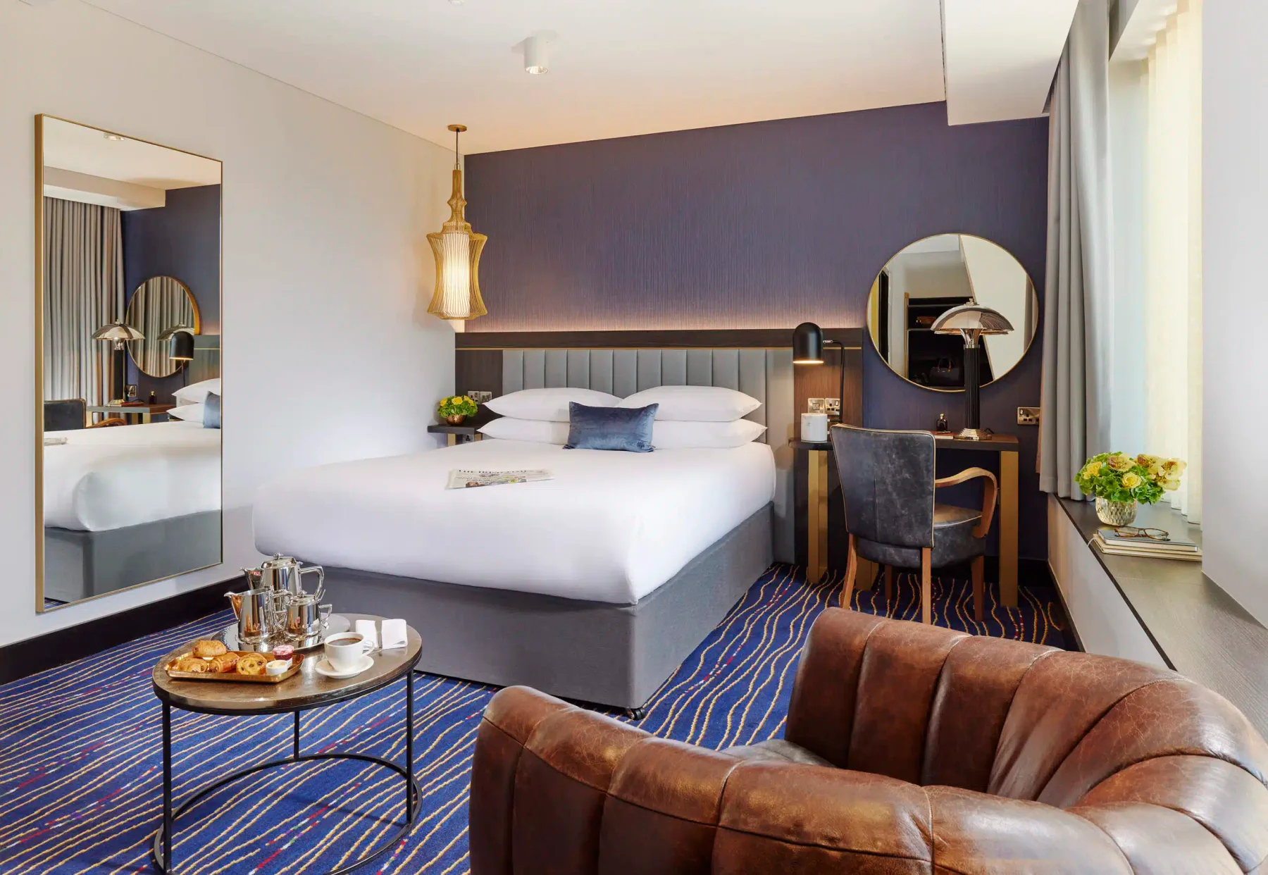 Representative hotel space: A hotel bedroom with a large bed, desk, and seating.