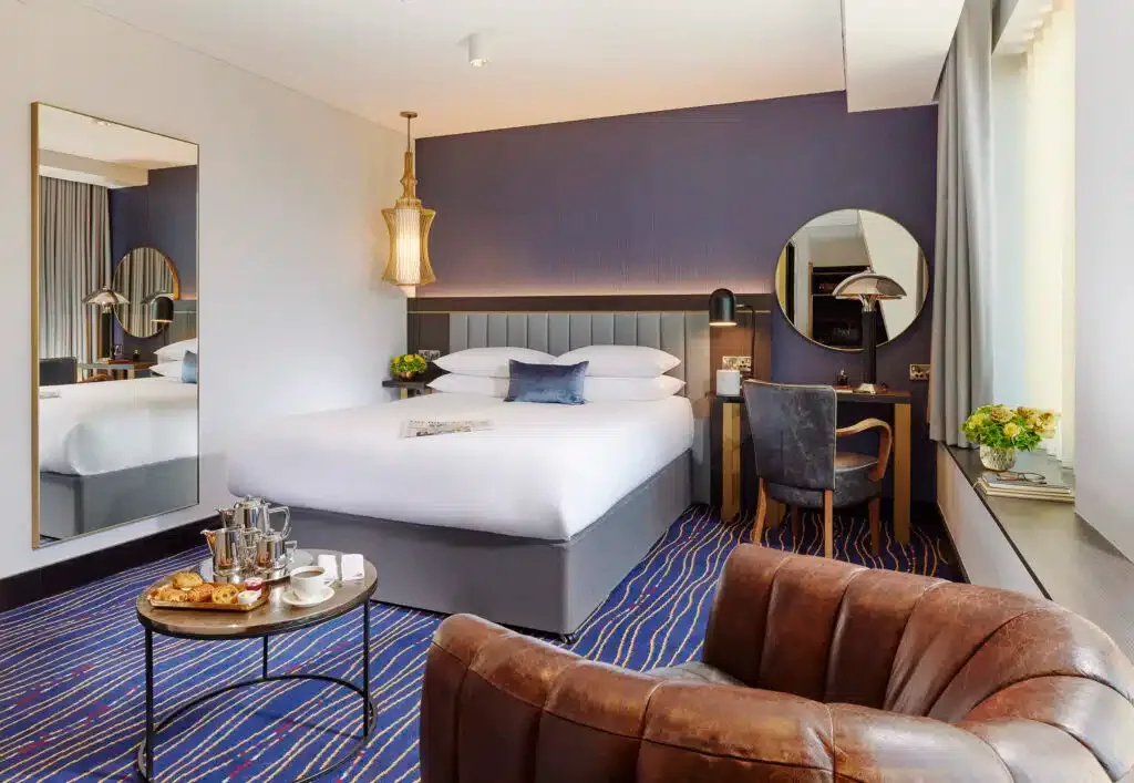 Representative hotel space: A hotel bedroom with a bed, desk, and seating area.