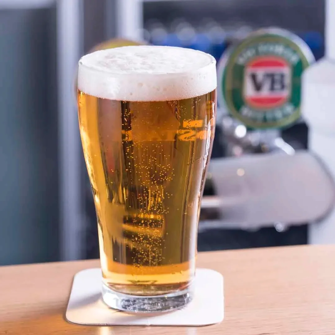 Espacio representativo del hotel: Un vaso de cerveza está sobre un posavasos en un bar.