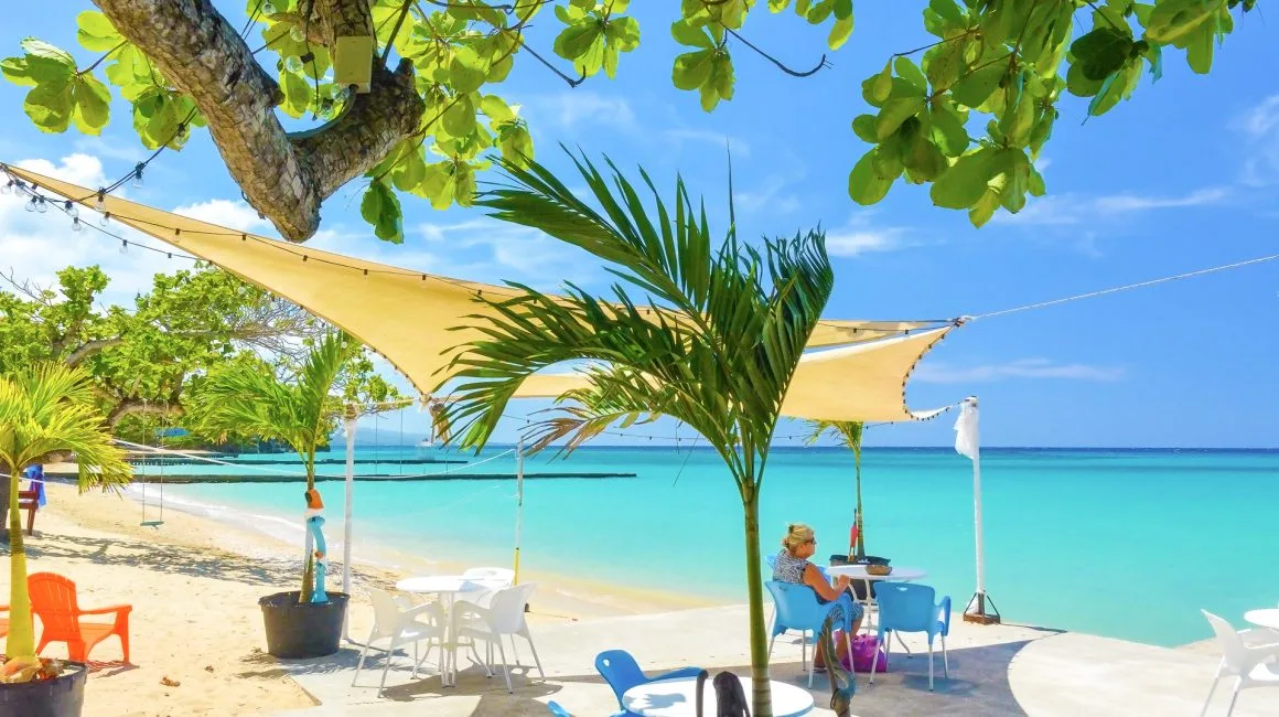 Espacio representativo del hotel: Una playa soleada con agua turquesa, orilla arenosa y asientos a la sombra.