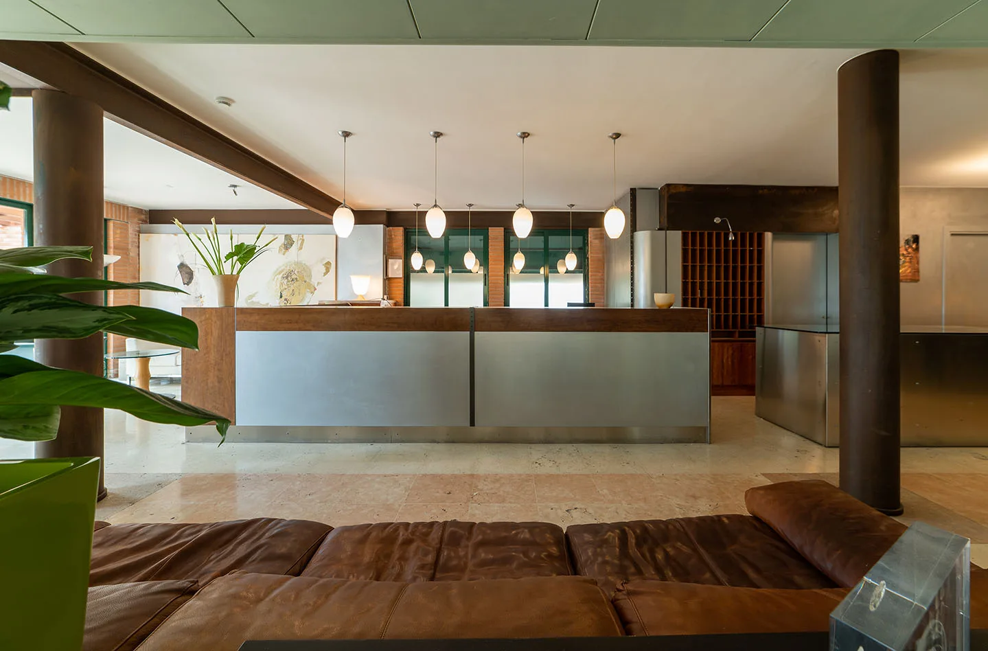 Representative hotel space: A hotel reception desk sits behind a low seating area with pendant lights overhead.