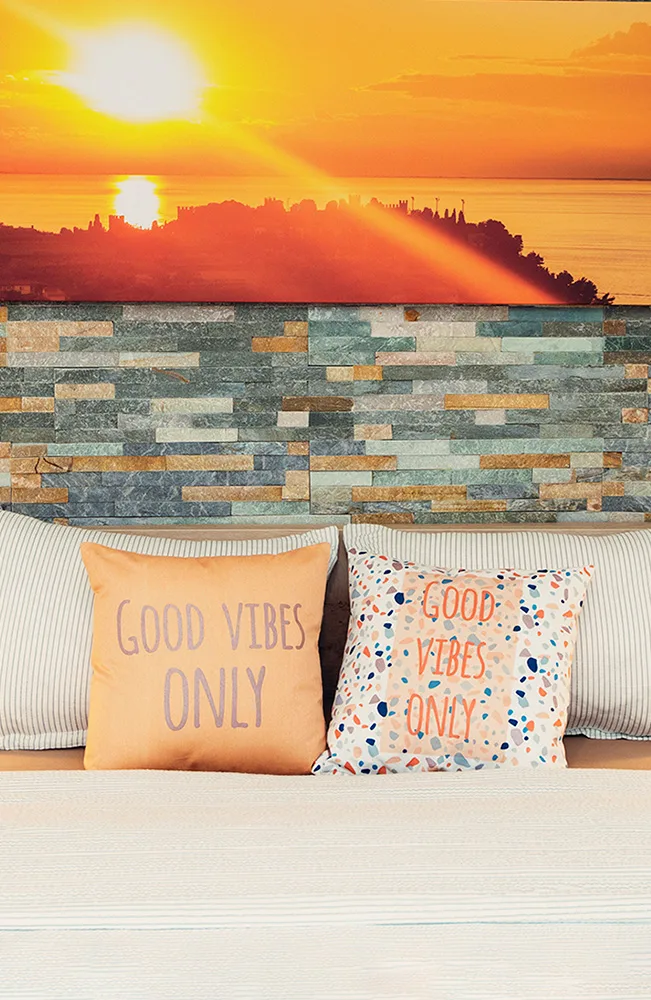 Espacio representativo del hotel: Un asiento con cojines decorativos mira hacia una vívida puesta de sol.