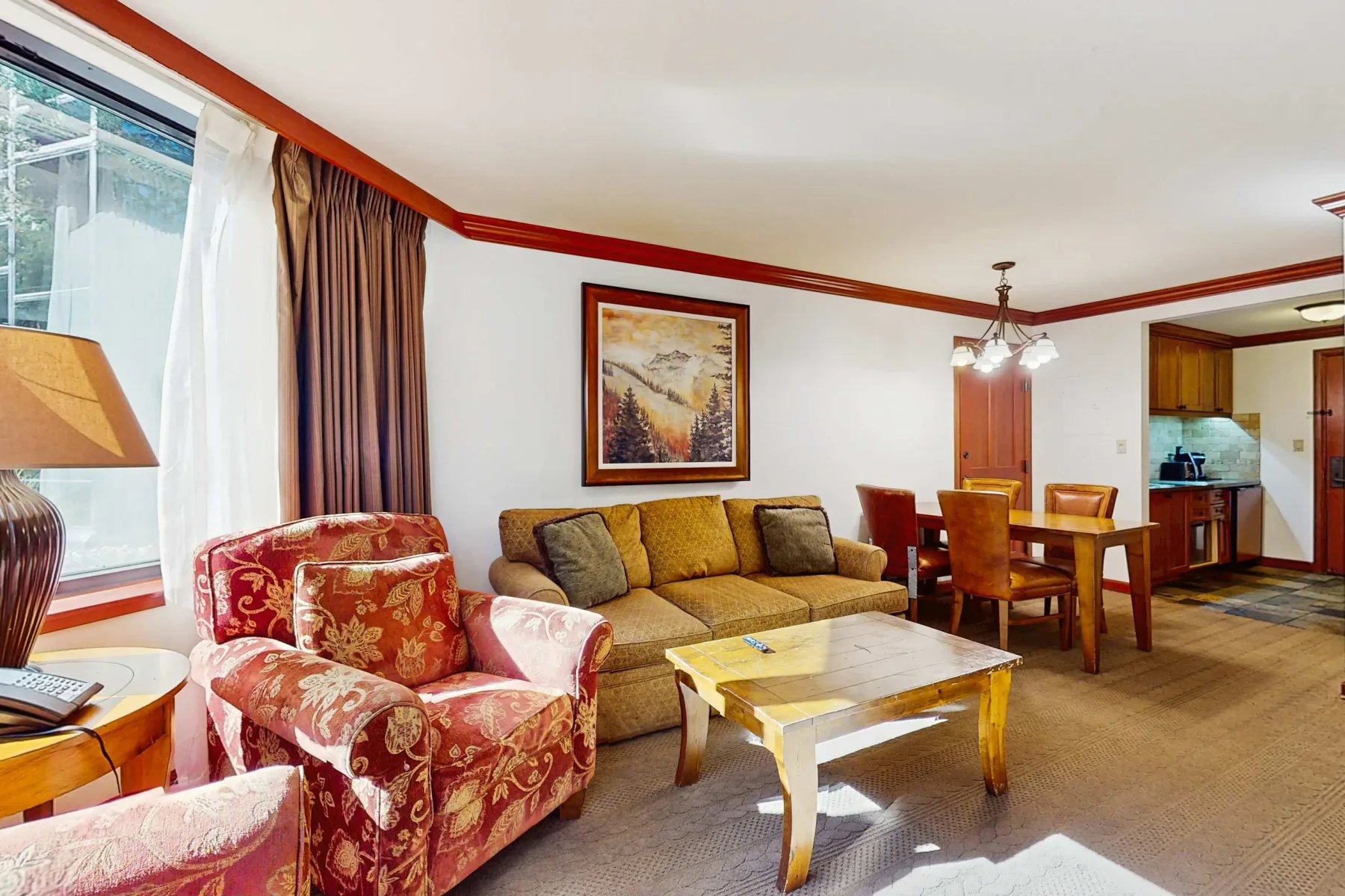 A living room with seating around a coffee table and a dining area.