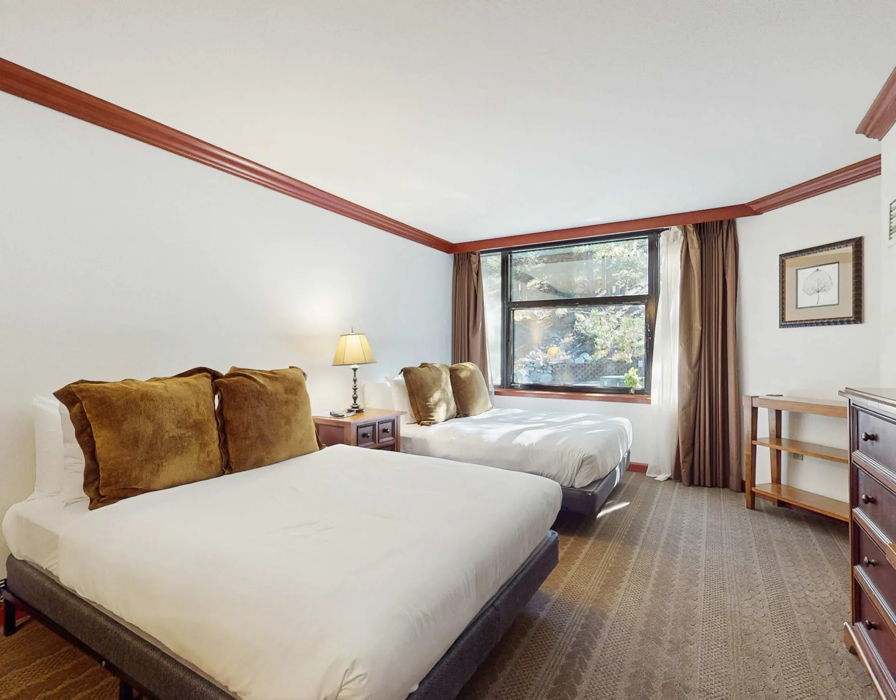 A bedroom with two beds, a window, and bedside furnishings.
