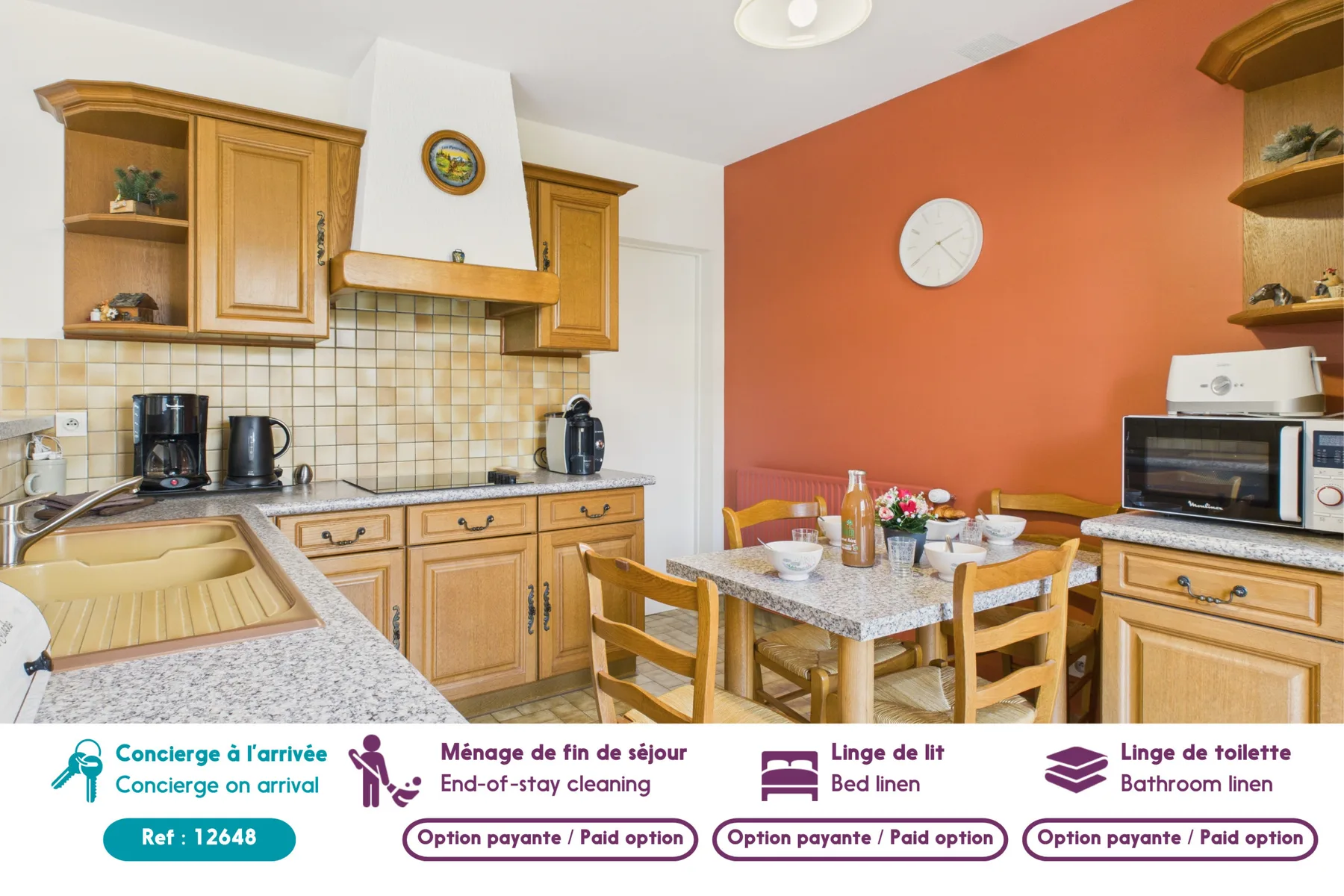 A kitchen with wooden cabinets and a dining table beside an orange wall.