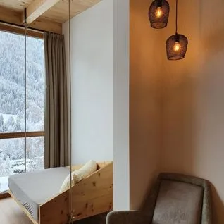 Espacio representativo del hotel: Un dormitorio con una cama junto a una gran ventana que da a un paisaje nevado.