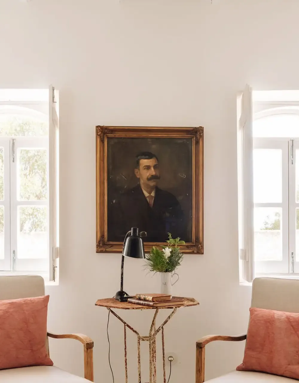 Representative hotel space: A bright sitting area with a framed portrait between two windows.