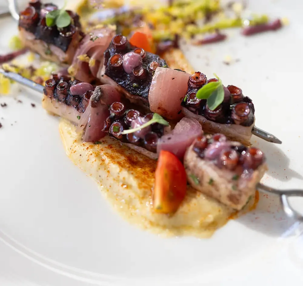 Representative hotel space: A plated seafood dish is topped with herbs and served over a pale sauce.