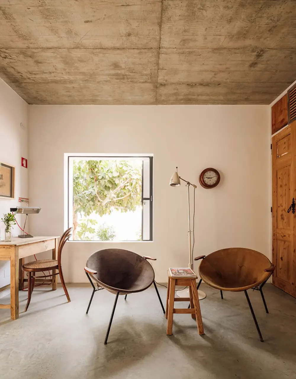 Representative hotel space: A bright room with seating, a small table, and a window overlooking greenery.