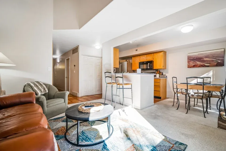 An open living area with seating, a kitchen island, and a dining table.
