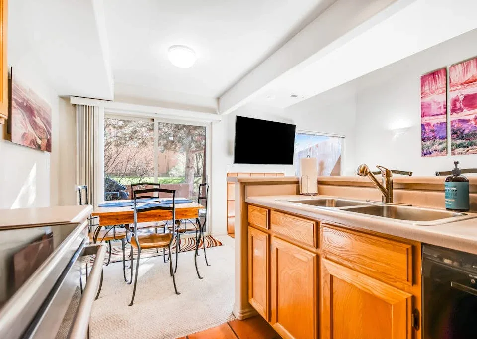 A bright open-plan kitchen and dining area with a wooden island and glass doors.
