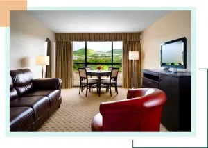 Representative hotel space: A hotel living area with seating, a dining table, and a window overlooking greenery.
