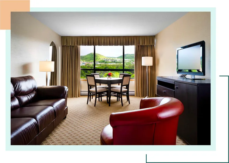 Representative hotel space: A hotel living area has seating, a dining table, and a large window.