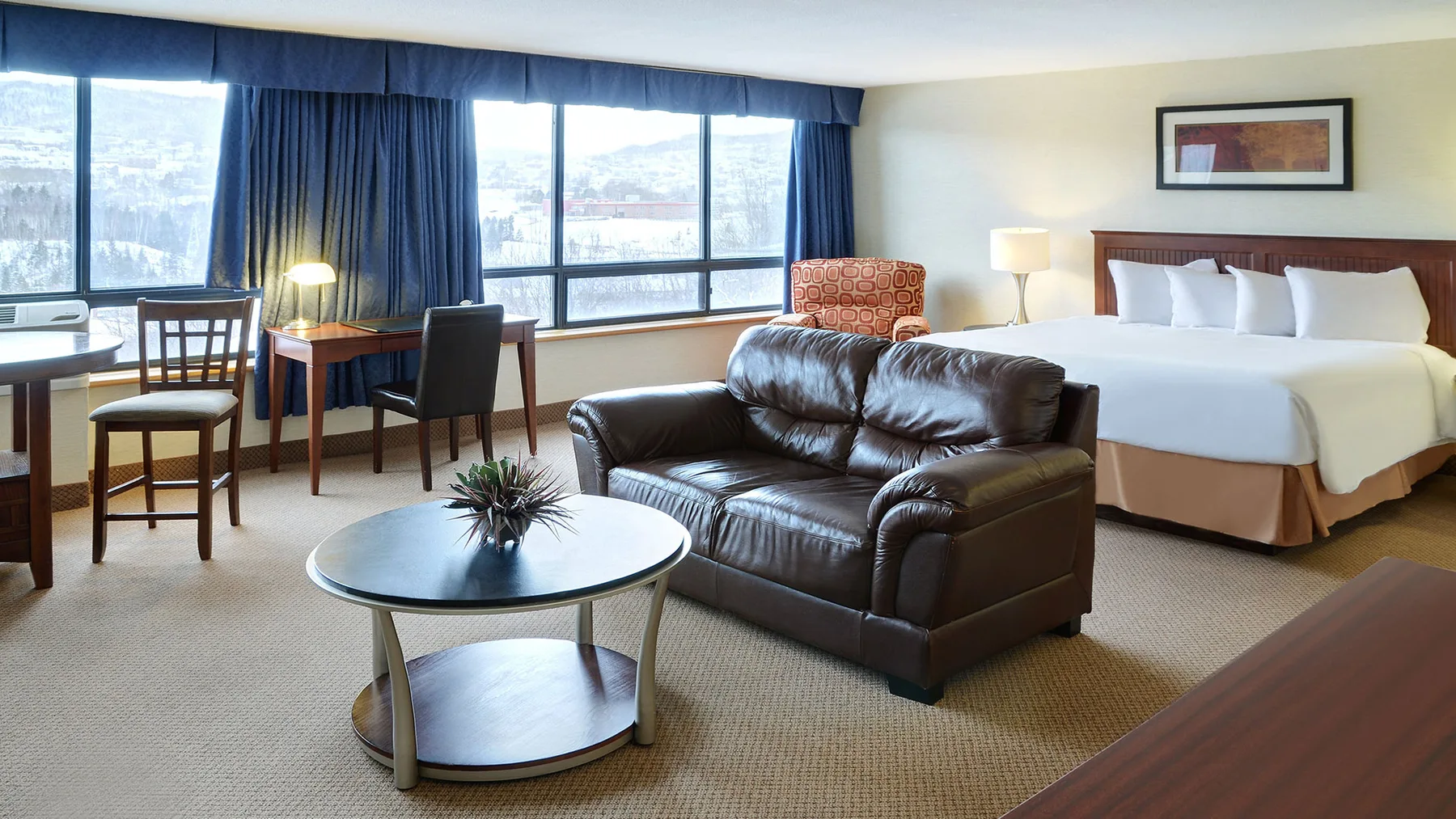 Representative hotel space: A hotel guest room has a bed, seating area, and large windows.