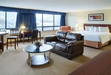 Representative hotel space: A hotel room with a bed, seating area, and large windows.