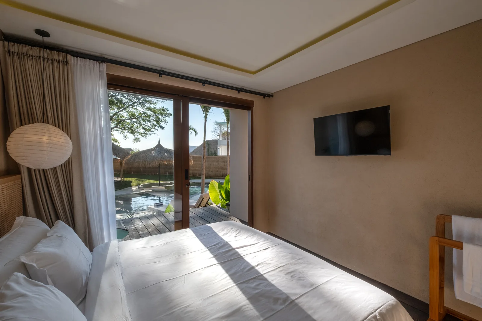 Un dormitorio con una cama junto a puertas de vidrio que dan a un patio.